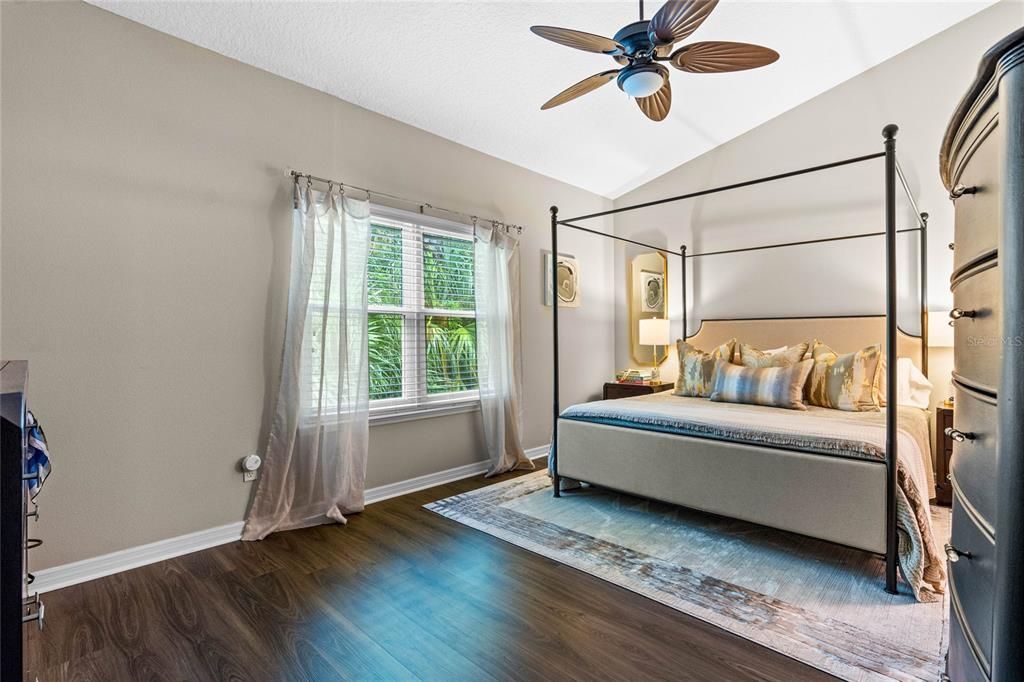 Spacious primary bedroom with new vinyl flooring installed in 2023 and large windows