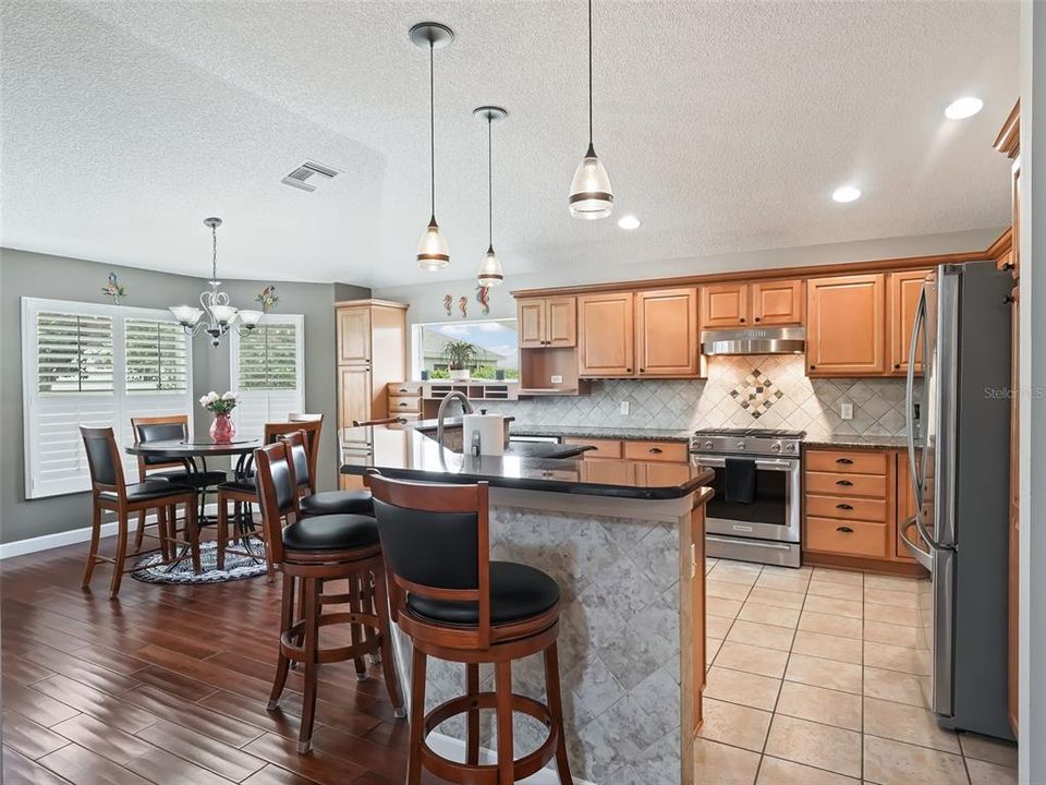 Stone countertops, tiled backsplash and tiled front of bar, no more scuffing! Pendant lighting, tower cabinetry with desk system! Wine cooler!