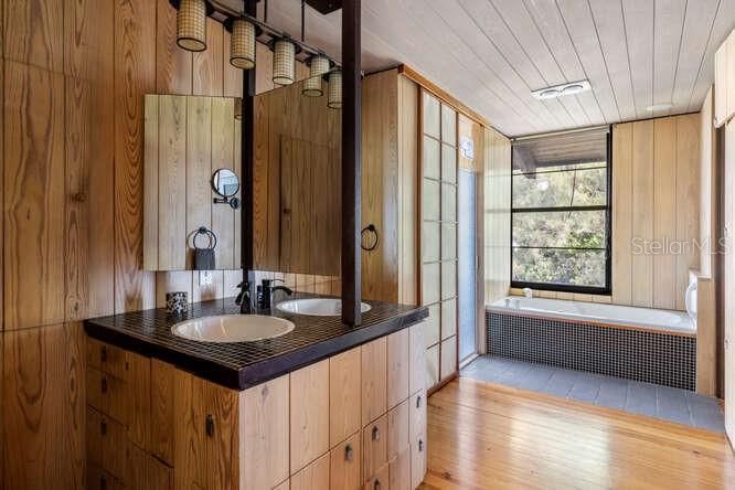 Primary bathroom with Heart of Pine floors and original hardwood cladding