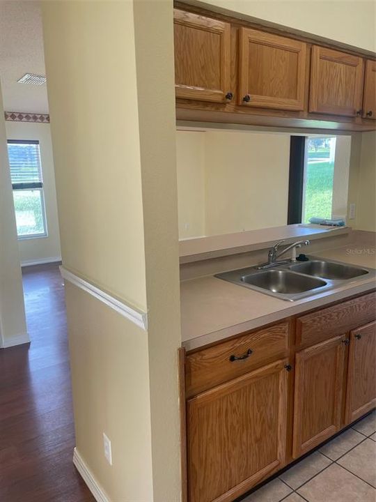 Kitchen has a double sink nd a serving counter that opens to the living/family room