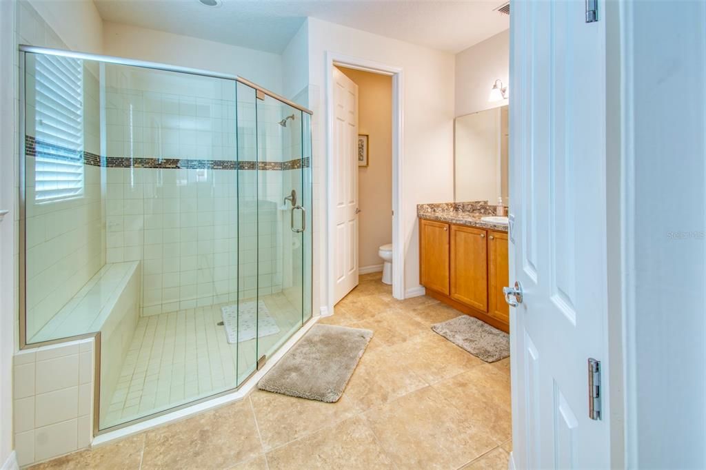 The bath features a large frame-less glass shower enclosure with seat - a large vanity and private watercloset