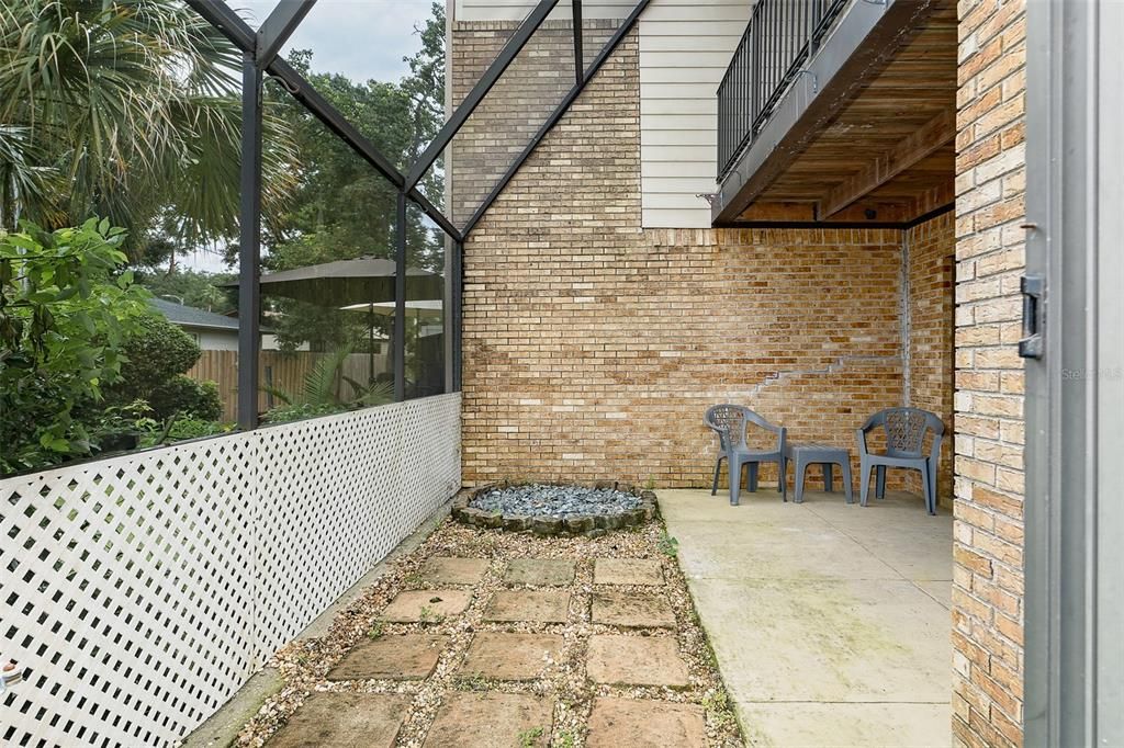 Outdoor screened area with room for plants and a small firepit.