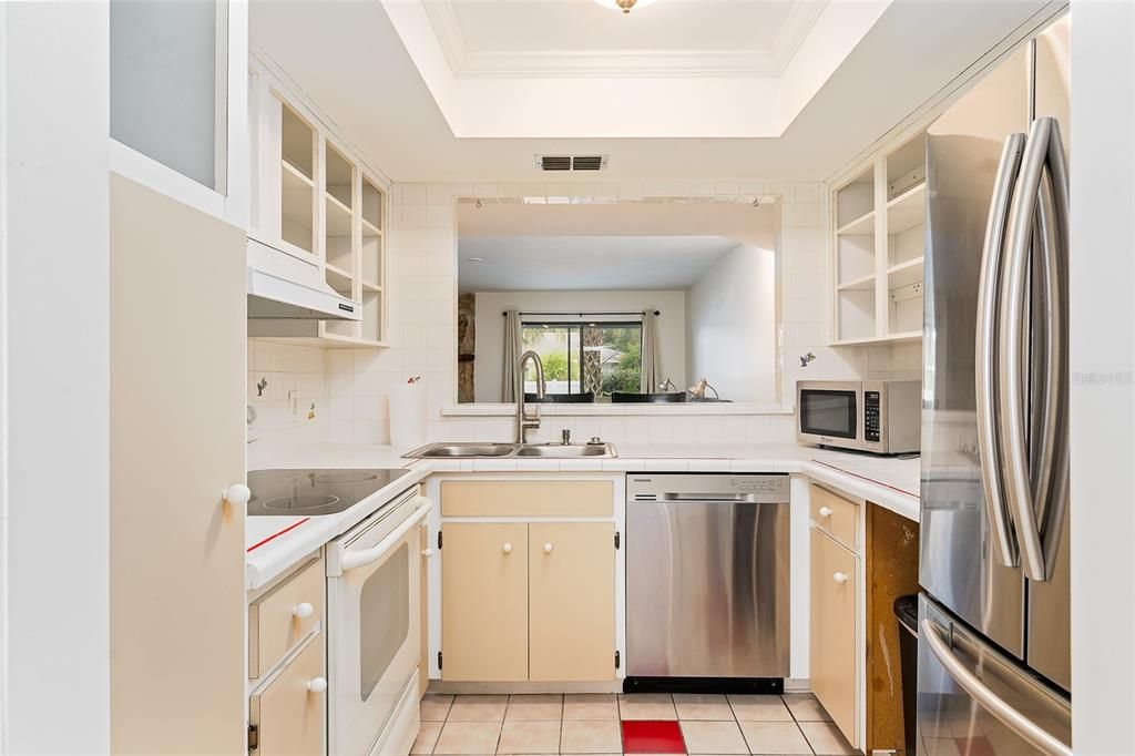 Kitchen with open shelving on top, stainless & white appliances , Microwave provided.