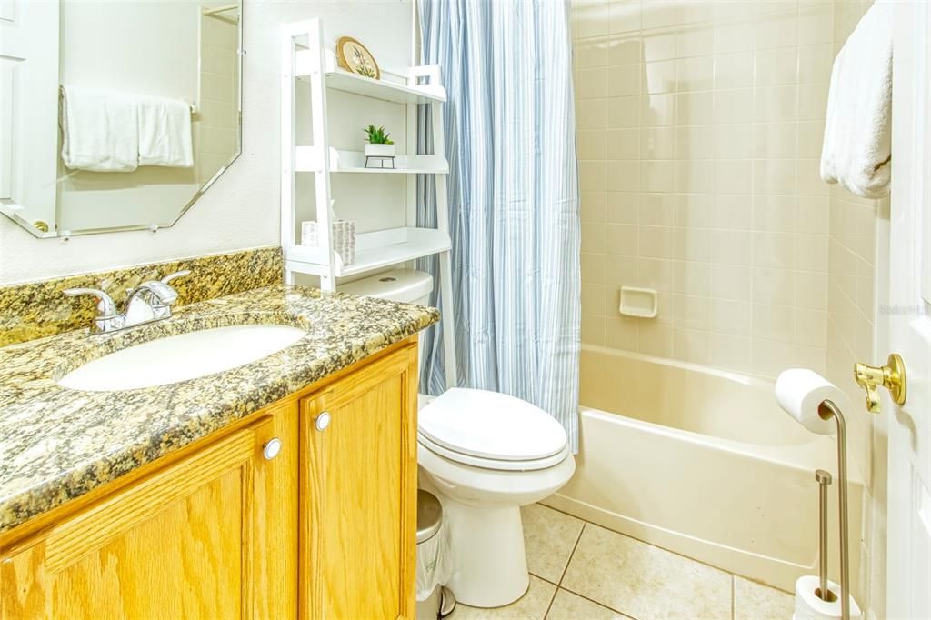 The 2nd bath is bright with a granite counter, seamless tub/shower combination