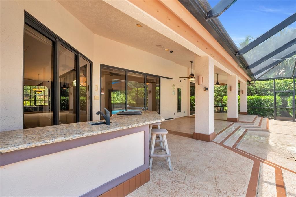 Patio view with ceiling fan, outdoor seating, and lanai