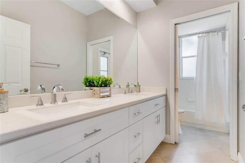 Shared bathroom with quartz double sink vanity