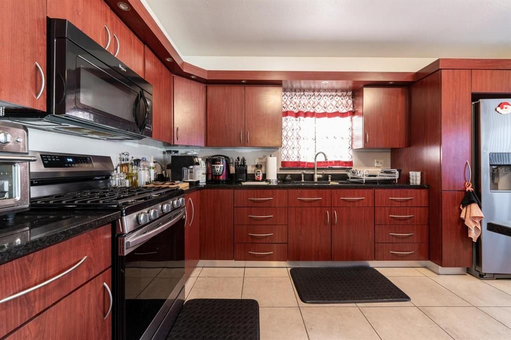 Updated kitchen with wooden cabinets and tile flooring