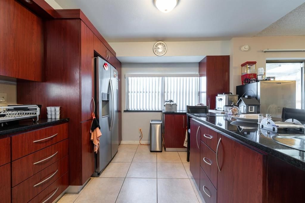 Updated kitchen with wooden cabinets and tile flooring