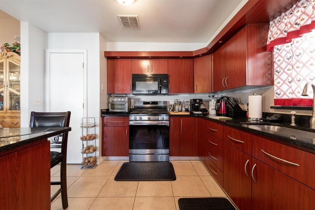 Updated kitchen with wooden cabinets and tile flooring