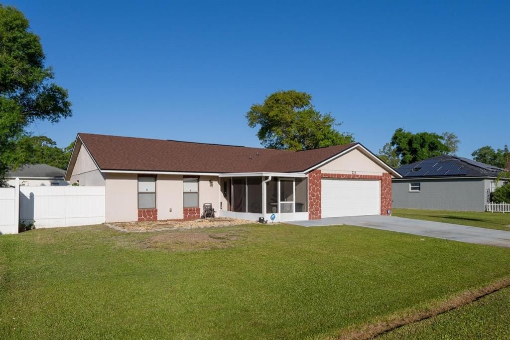 Front view of the property showing the screened front porch and the attached garage