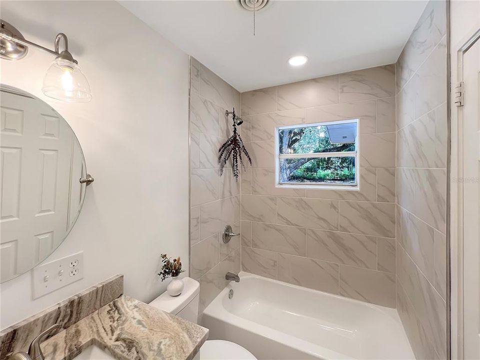 Updated Bathroom featuring new tub with a custom tiled surround