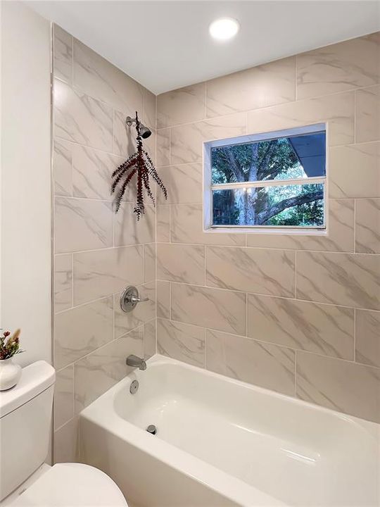 Updated Bathroom featuring new tub with a custom tiled surround