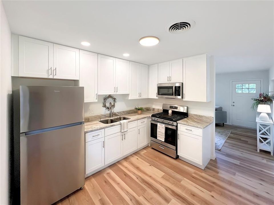 Updated Kitchen featuring new 42" White ShakerCabinets, Granite Countertops, Stainless Steel Appliances, LVP Flooring, Paint and Recessed Lighting