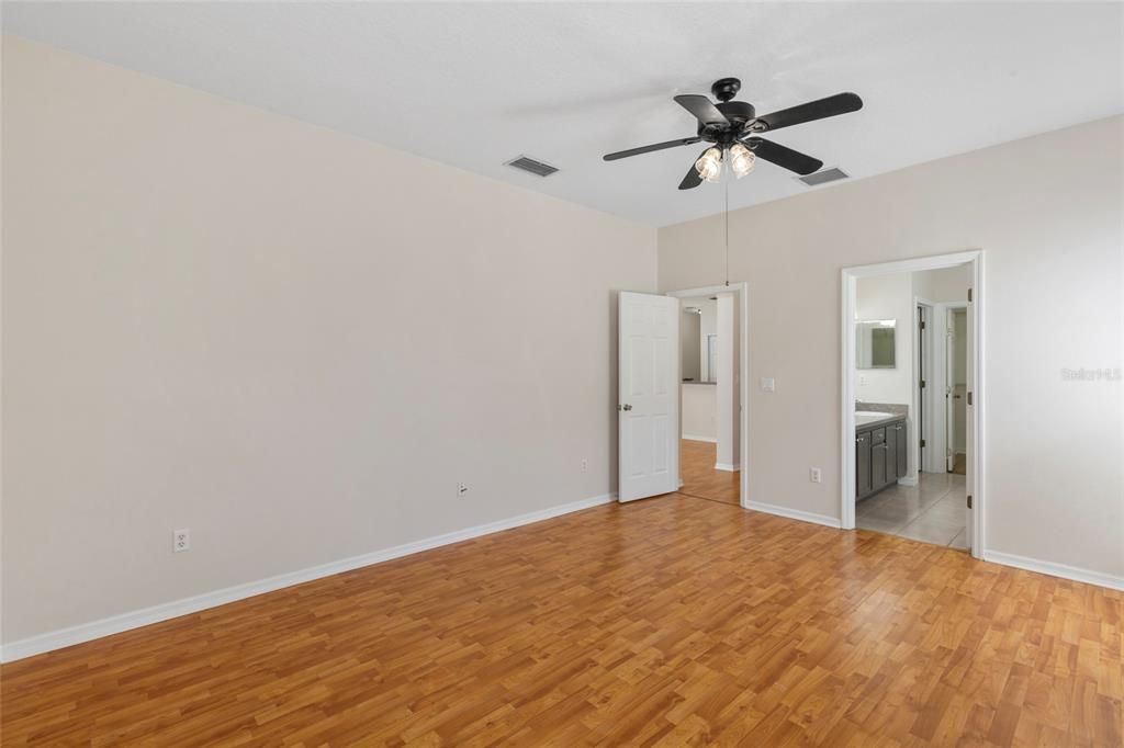 Master bedroom with ceiling fan and en-suite master bath.