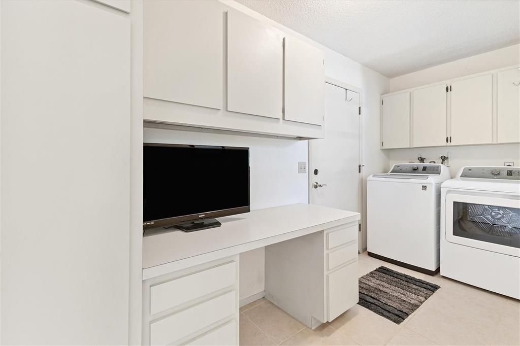 generous inside laundry room with lots of cabinets & storage space off kitchen area