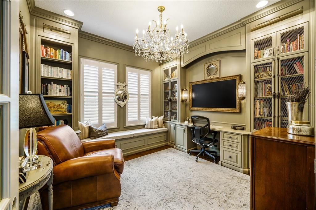 Peaceful and exquisite home office/study with double French Door access, built-in window seat, desk, Samsung Frame TV, bookshelves, crown molding and roll-out shelving hiding the copier and shredder - a place to think with a place for everything!