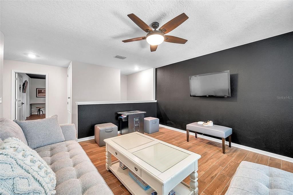 Upstairs bonus room with lunge, sofa and game room