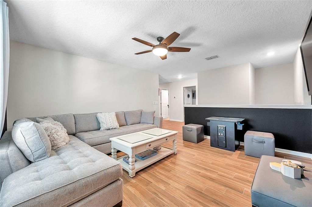 Upstairs bonus room with lunge, sofa and game room