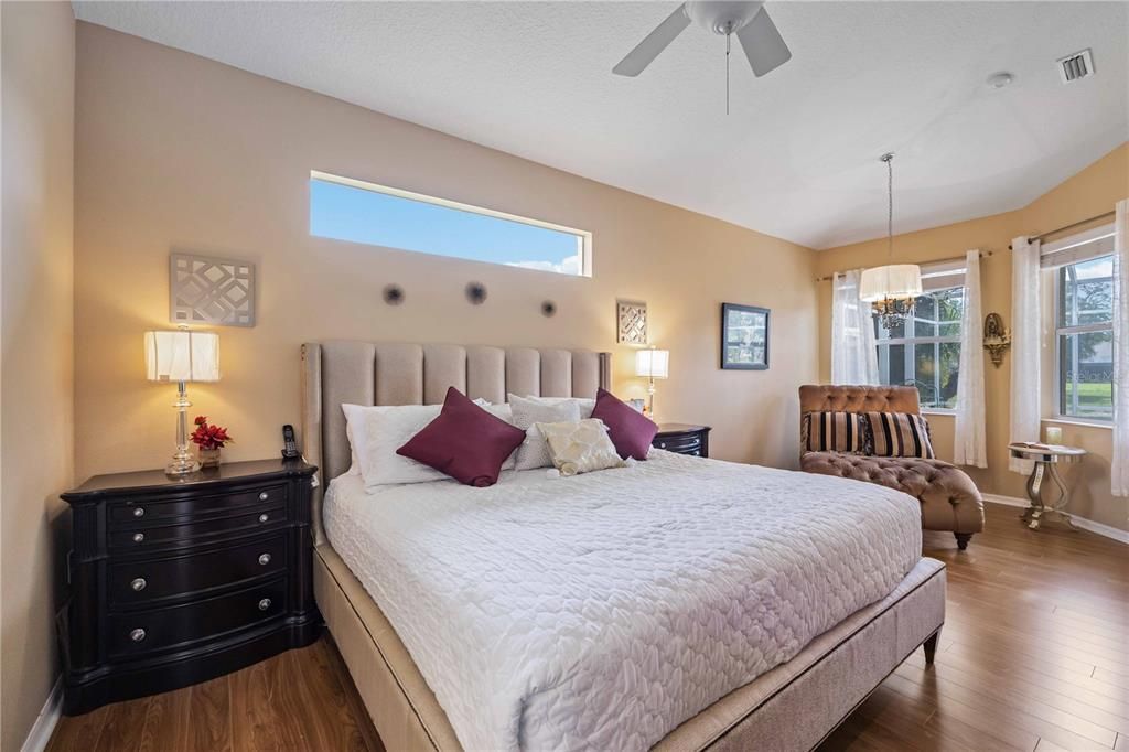 Primary suite has large open windows and high ceilings creating a light airy retreat, hardwood flooring.