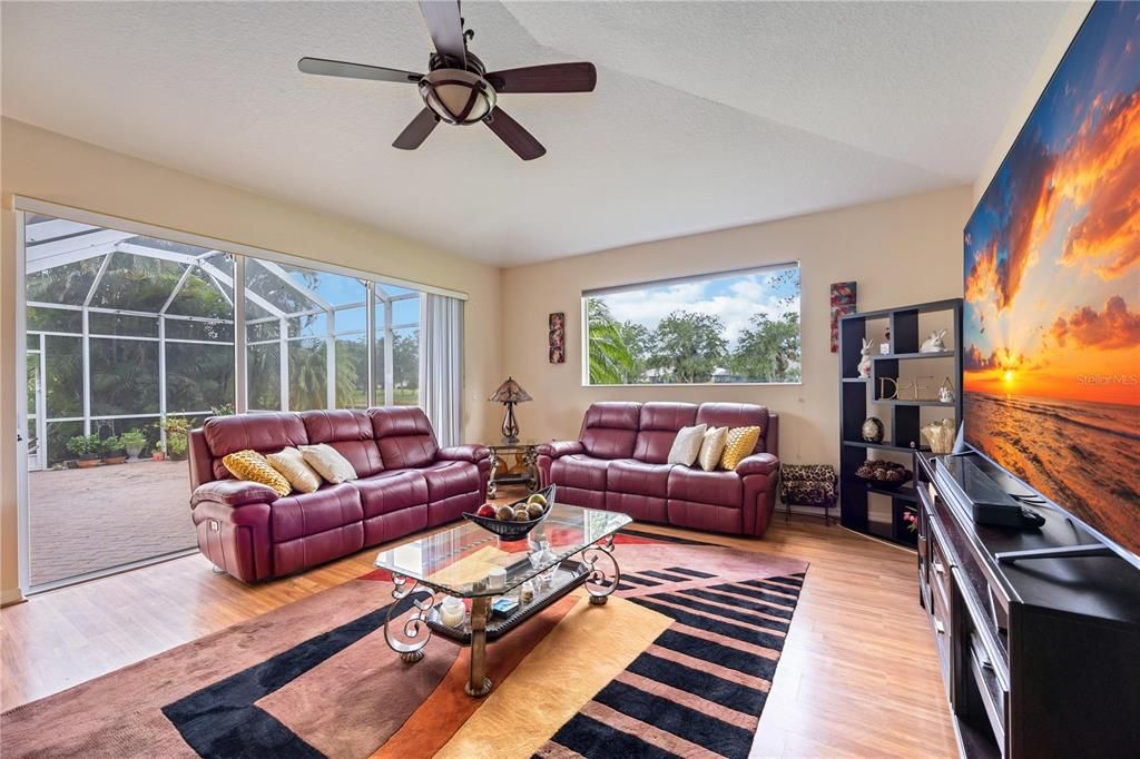 Triple sliding doors creating a seamless flow into the lanai directly from the family room while bringing in a luminous natural light, wood flooring.