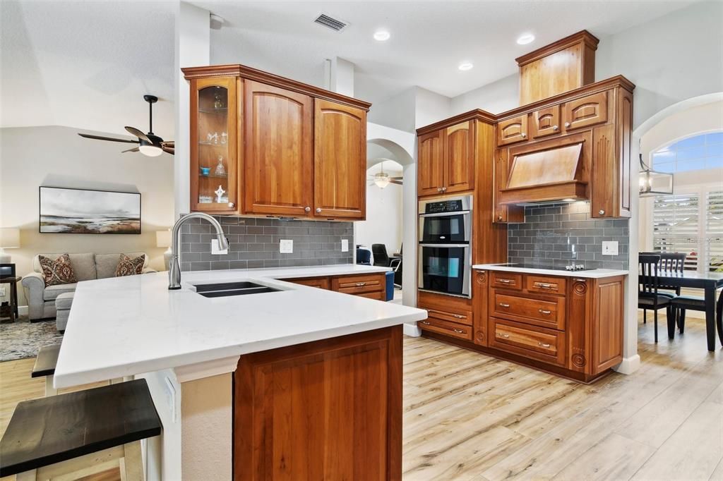 Perfectly situated in the heart of the home the kitchen delivers timeless cabinetry alongside STAINLESS STEEL APPLIANCES, modern solid surface counters paired with a complimentary subway tile backsplash and there is seating on the breakfast bar in addition to a casual dining nook.