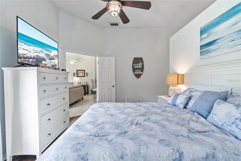 View of the primary bedroom with the living & dining rooms in the background