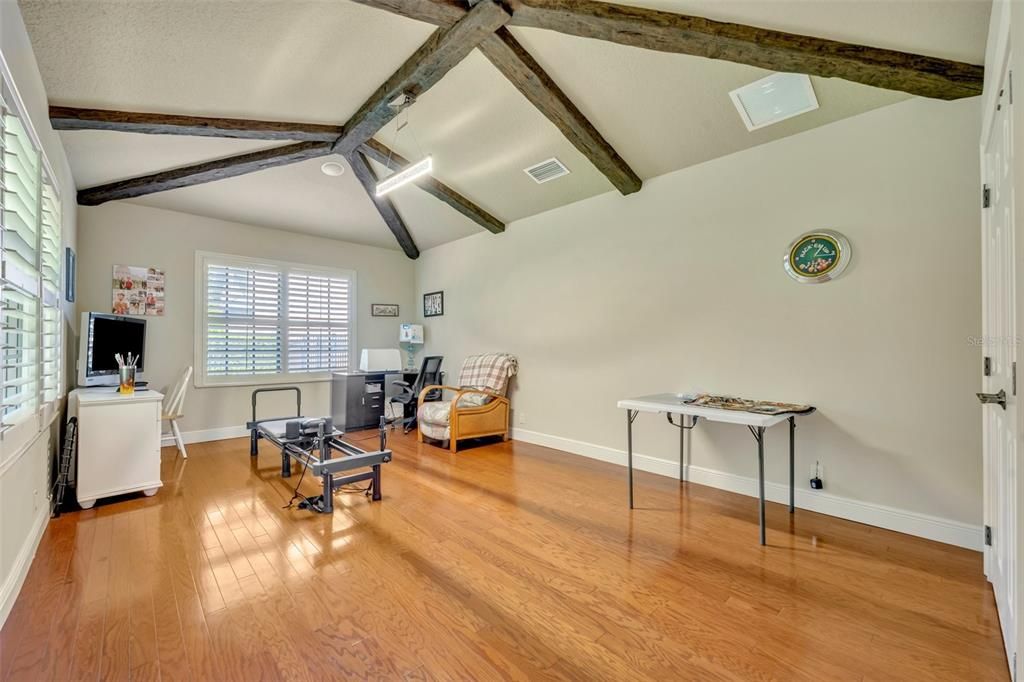 4th Bedroom with custom wood ceiling beams, wood floors and plantation shutters