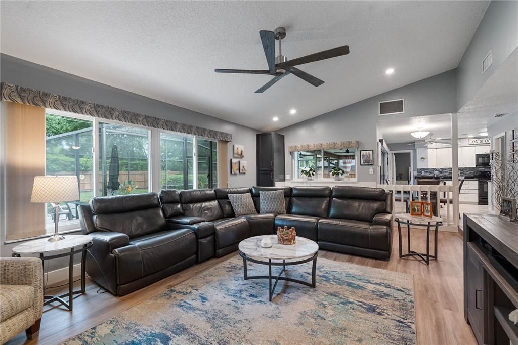 Family room/living room, looking towards the kitchen and breakfast nook; large windows overlook the pool and lanai