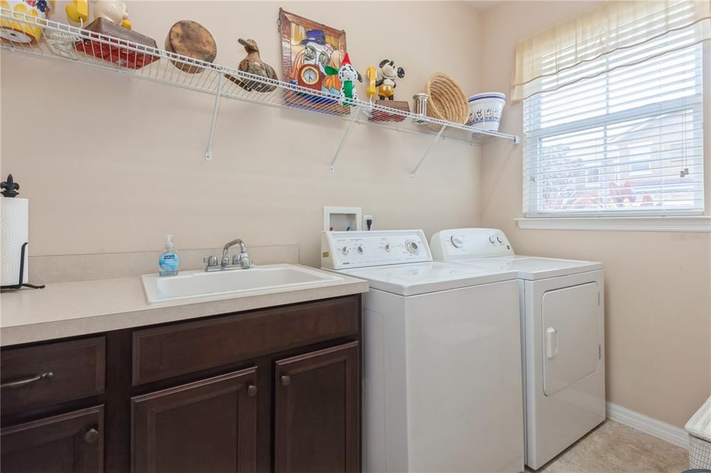 Inside laundry room with utility sink and cabinets