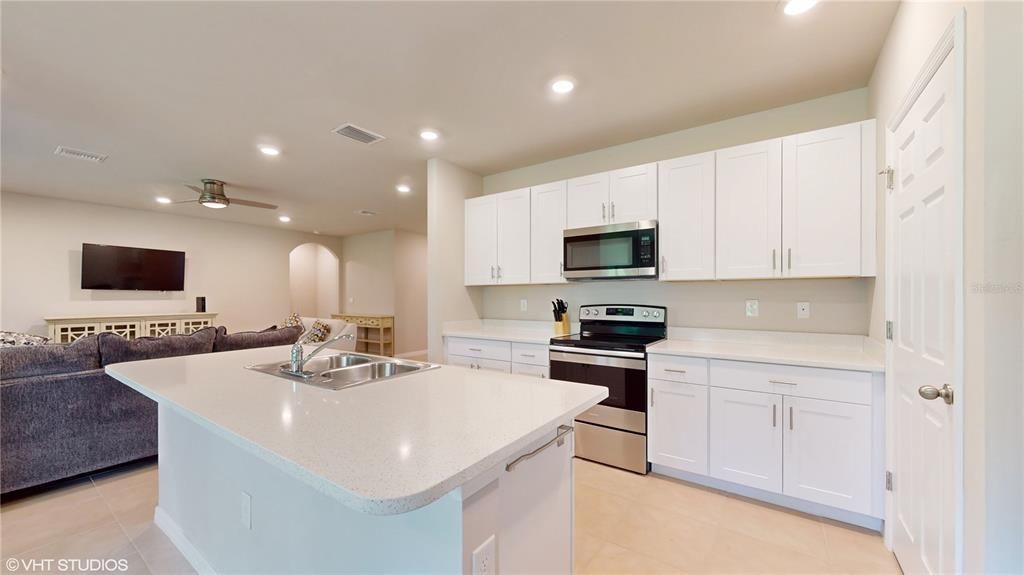 BEAUTIFUL KITCHEN WITH WHITE SHAKER CABINETS AND WRAPPED IN QUARTZ COUNTERTOPS.