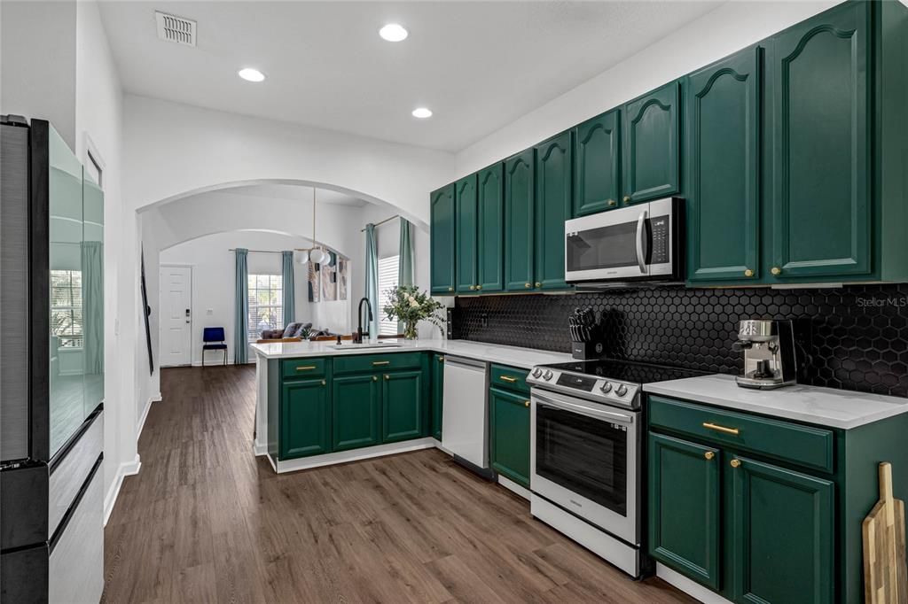 View of fully equipped kitchen looking through to the dining and living room areas.