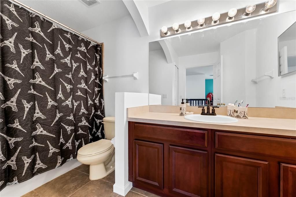 Upstairs secondary bathroom with vanity and tub/shower.