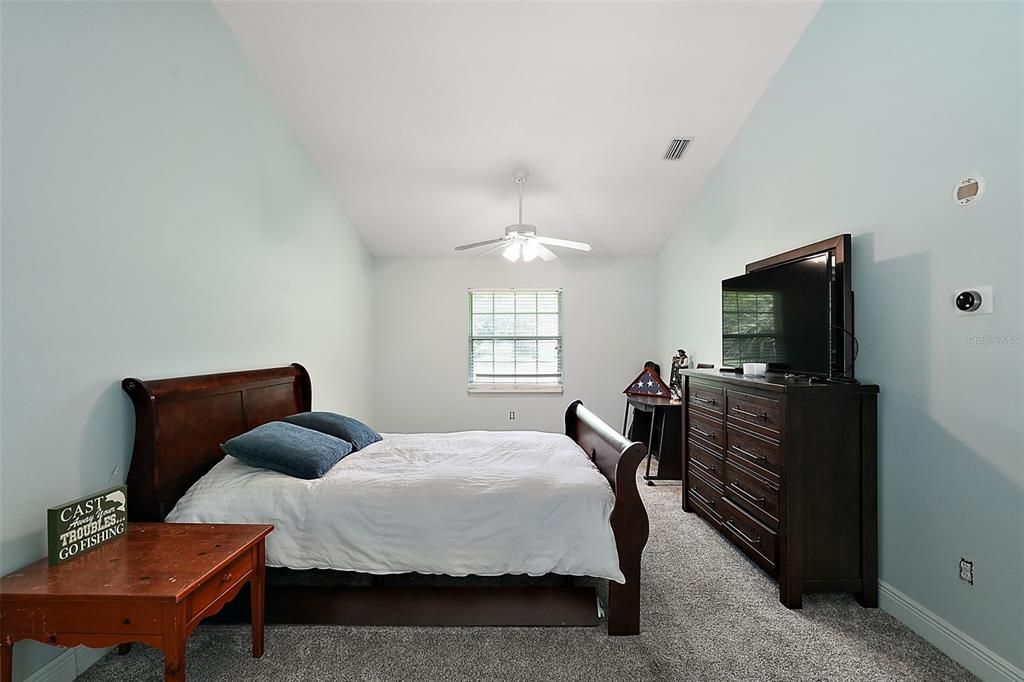 Bedroom in the in-law suite. With carpet and vaulted ceiling.