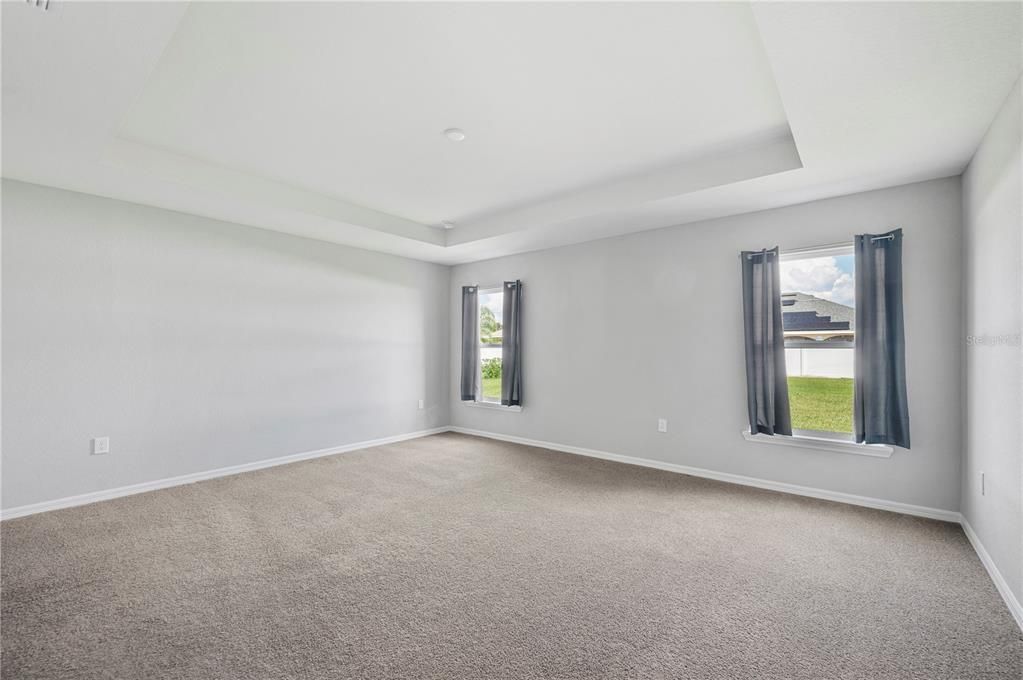 Large Primary Bedroom with windows overlooking backyard.