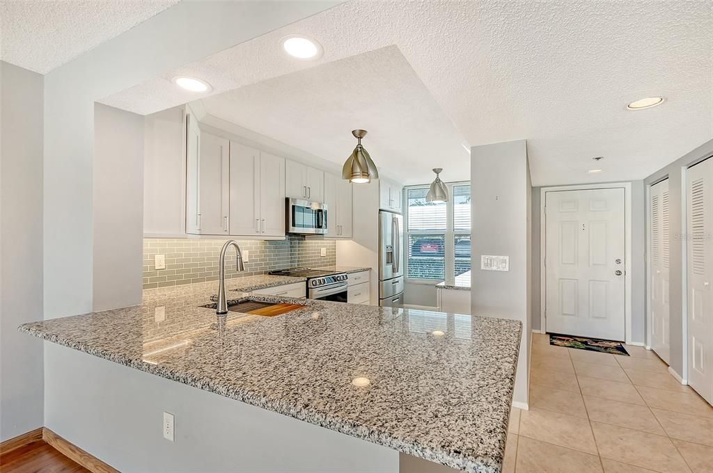 Kitchen with breakfast bar and foyer with two closets at entry