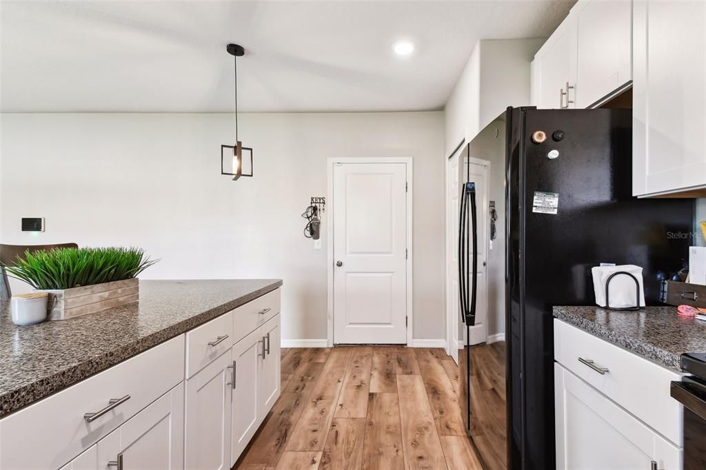 Kitchen view leading to garage entry