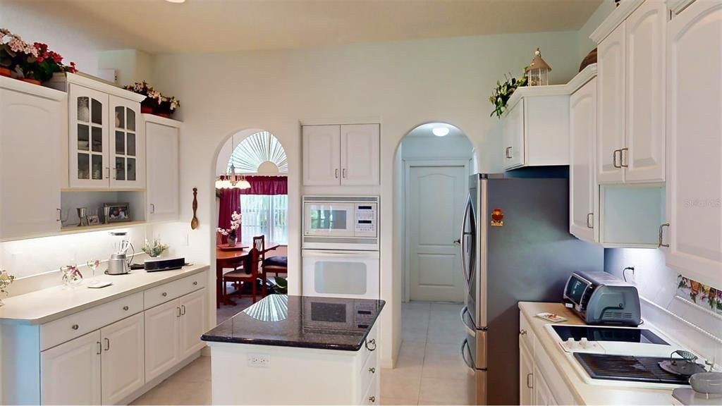 Upgraded cabinetry with crown molding, large pull-out drawers, and select cabinets featuring glass doors—offering a perfect blend of elegance and practicality, with direct access to the dining area for seamless entertaining.