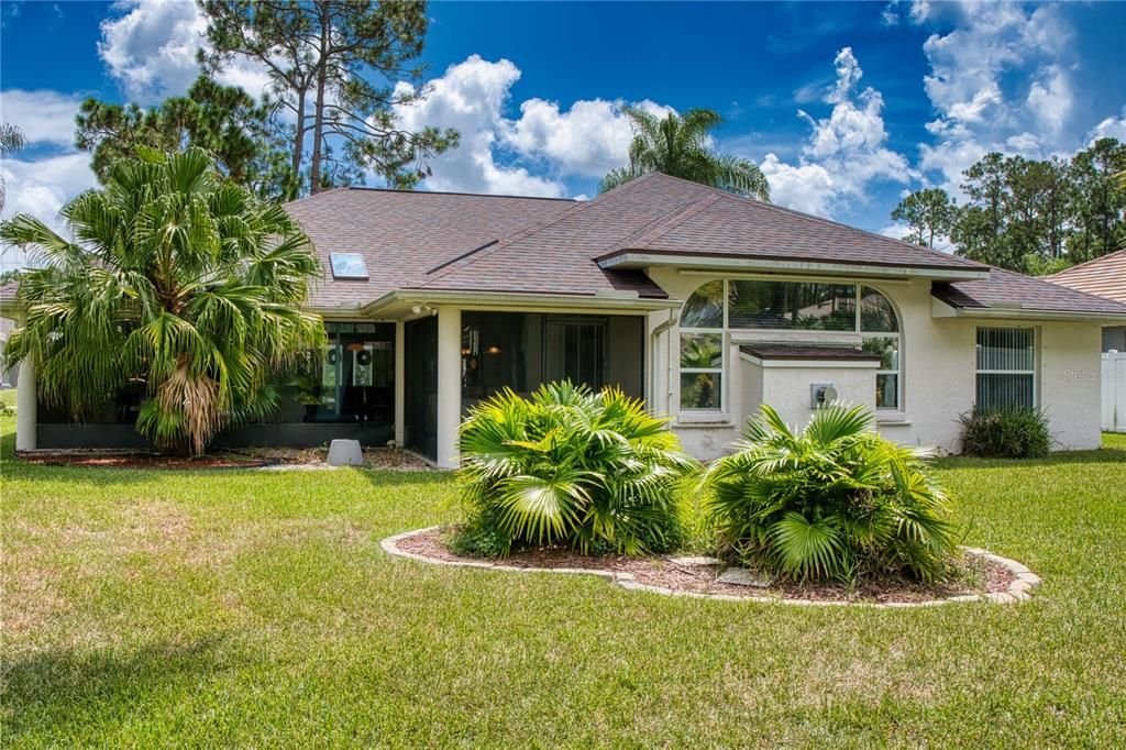 Expansive backyard featuring lush Florida landscaping, with plenty of room to add your dream pool—perfect for enjoying the natural beauty and serenity of your outdoor space.