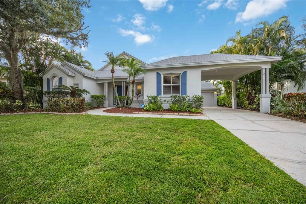 Key Biscayne style home with tropical landscaping, portico car parking with 2-car garage