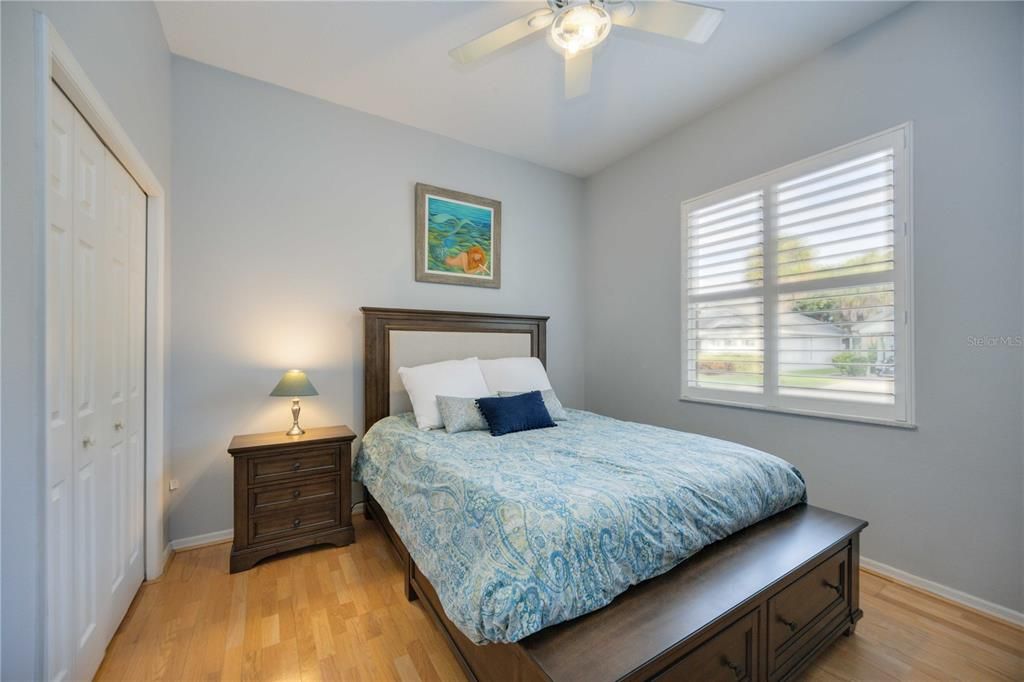 Second bedroom with hardwood flooring, ceiling fan and storage closet