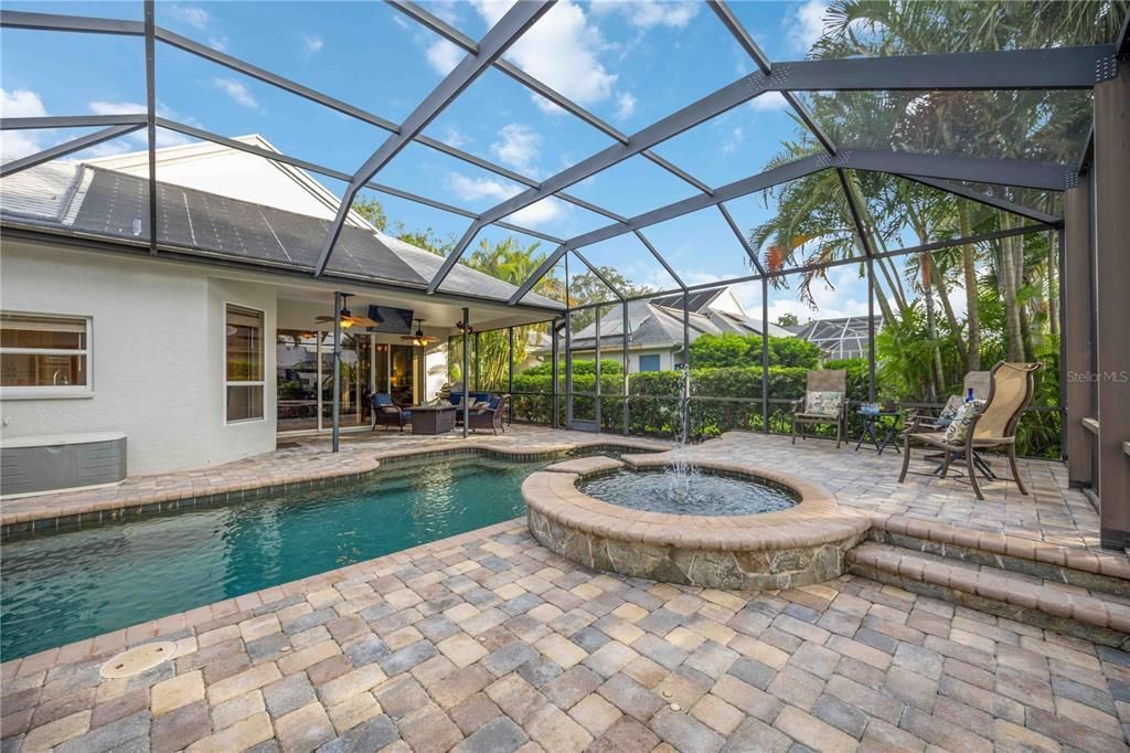 Oversized screened in lanai with saltwater pool and spa and multiple lounge spots to relax pool side