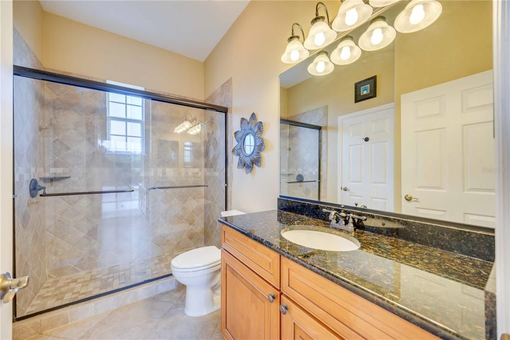 Oversized third bedroom with hardwood flooring ceiling fan and storage closet