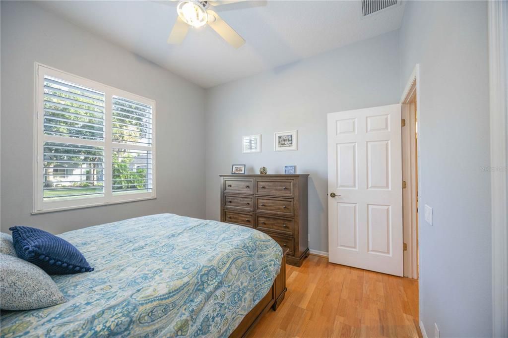 Primary bedroom has hardwood flooring and private ensuite bathroom with walk in closet