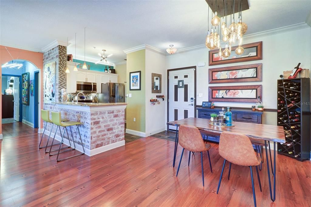 Open dining and kitchen area with breakfast bar looking  down the hall to bedroom and bath areas