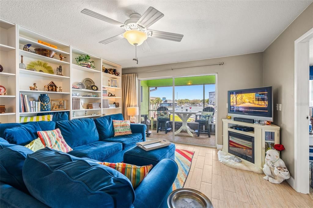 Large living room with ceiling fan and slider to the screened in balcony.