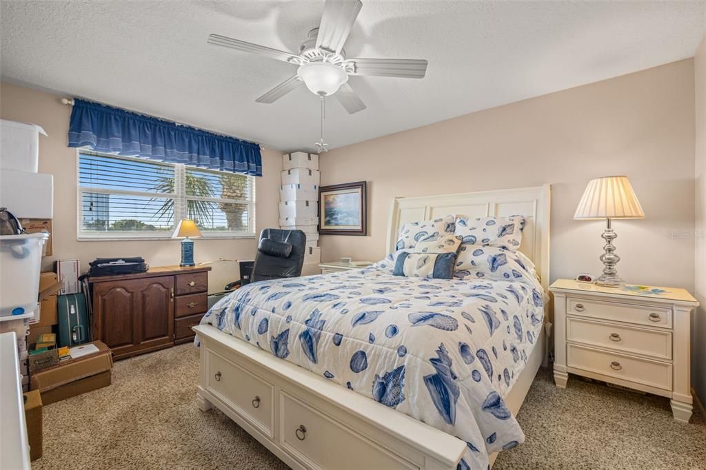 Primary bedroom can easily accommodate a king-sized bed!  Features newer windows, ceiling fan, sliding glass doors to the lanai, walk-in closet with extra built-storage as well as attic access.