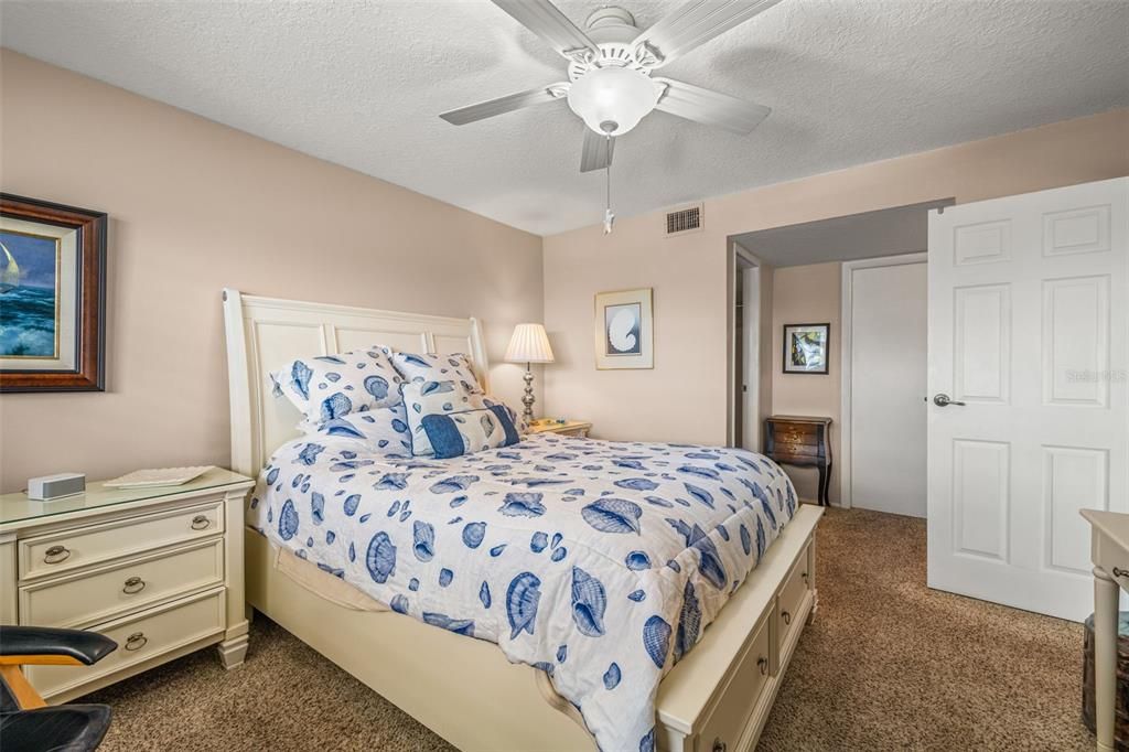 View toward the primary en-suite bathroom, walk-in closet and additional desk/dresser storage area.