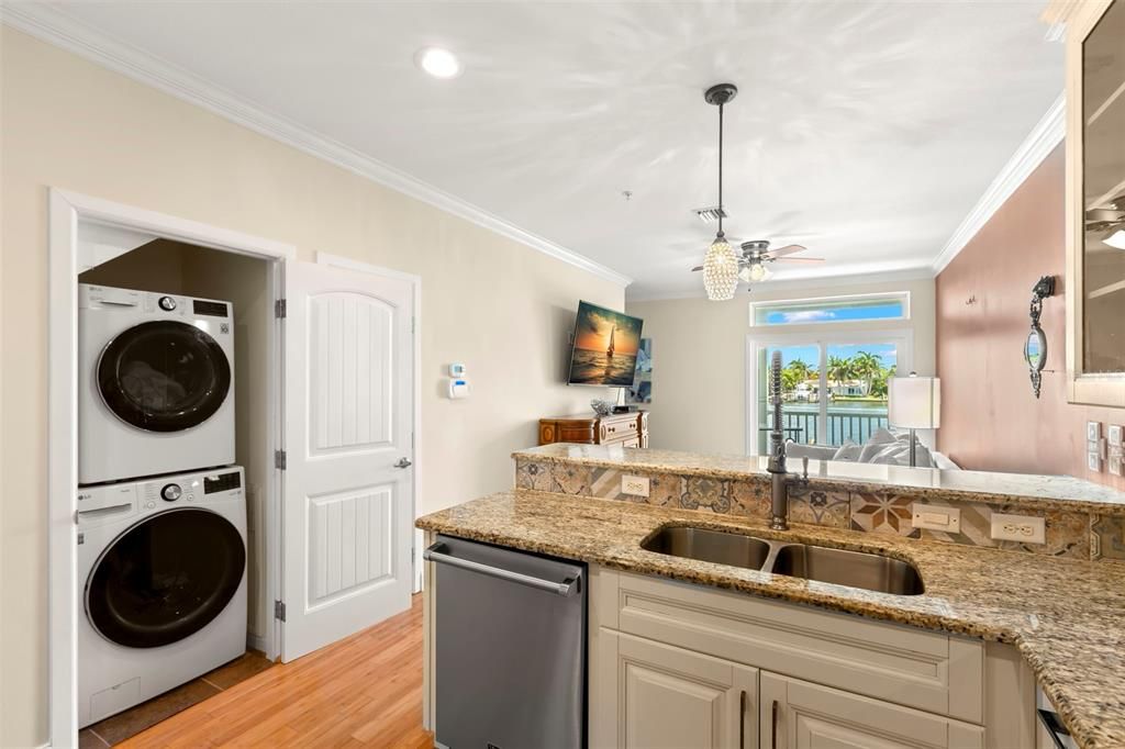 Convenience at its best! This kitchen not only offers great views and an open layout but also a hidden laundry closet with a sleek stackable washer and dryer—keeping everything you need within easy reach.