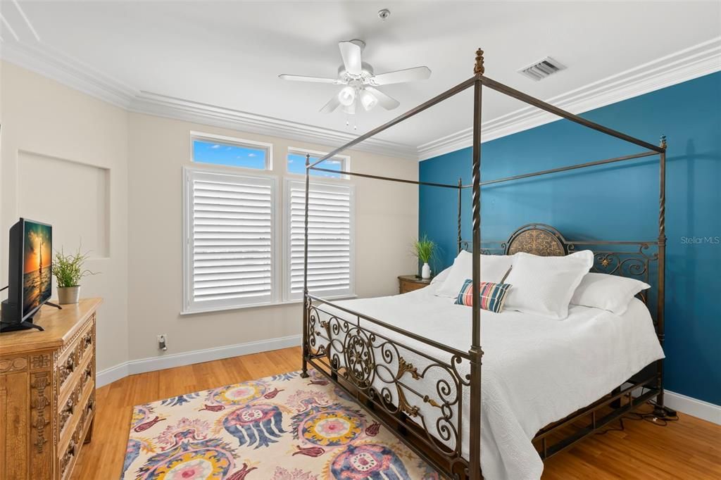 Wake up to sunshine and serene vibes in this beautifully appointed primary bedroom, featuring a calming blue accent wall and plenty of natural light.