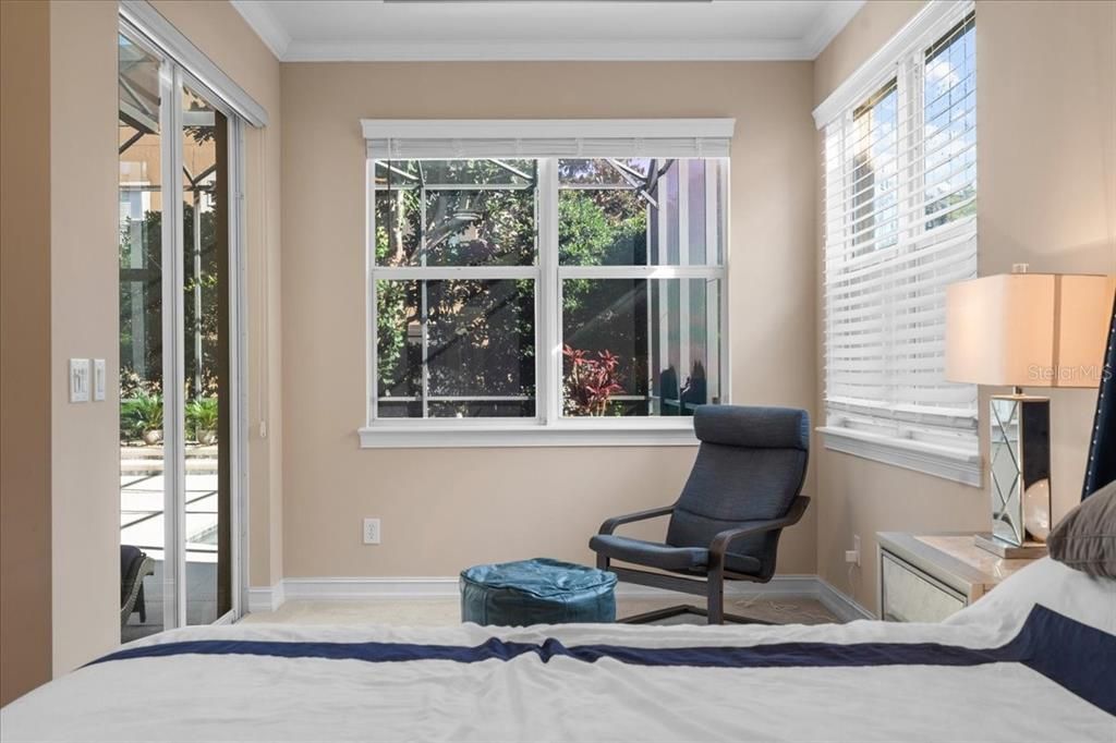 The sitting area in the Primary Suite leads to the lanai and pool deck.